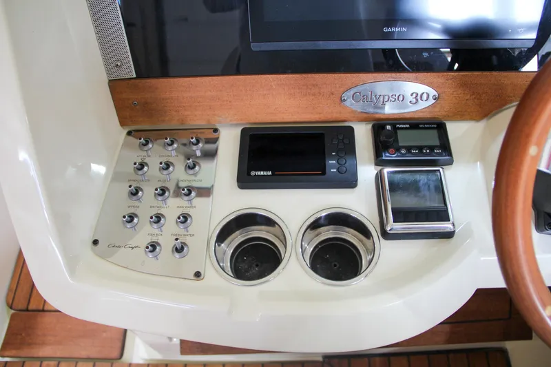 Slide: The Image of 2019 Chris-Craft Calypso 30 dashboard with controls and cup holders. - 22