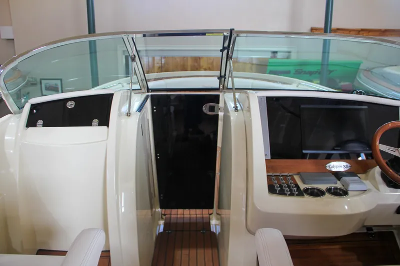 Slide: The Image of 2019 Chris-Craft Calypso 30 boat interior with sleek dashboard and glass windshield. - 24