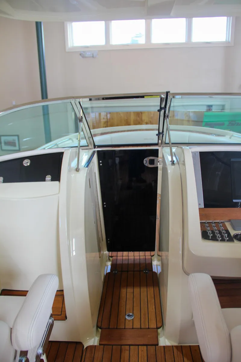 Slide: The Image of 2019 Chris-Craft Calypso 30 interior with teak flooring and modern dashboard. - 25