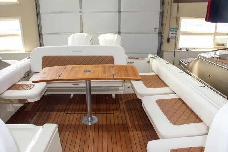 Slide: The Image of 2019 Chris-Craft Calypso 30 interior with teak flooring and cushioned seating. - 3
