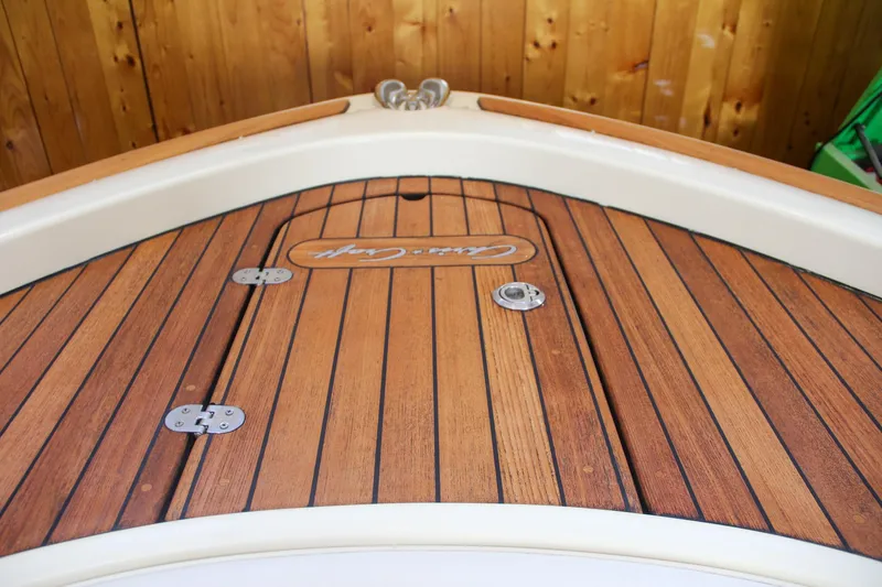 Slide: The Image of Chris-Craft Calypso 30, 2019, teak deck detail with logo, wooden background. - 30