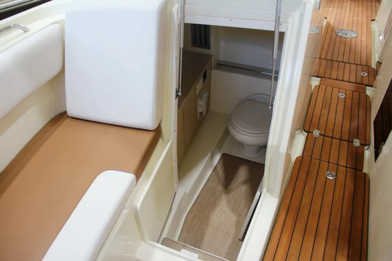 Slide: The Image of 2019 Chris-Craft Calypso 30 interior with seating, wooden flooring, and compact bathroom. - 31