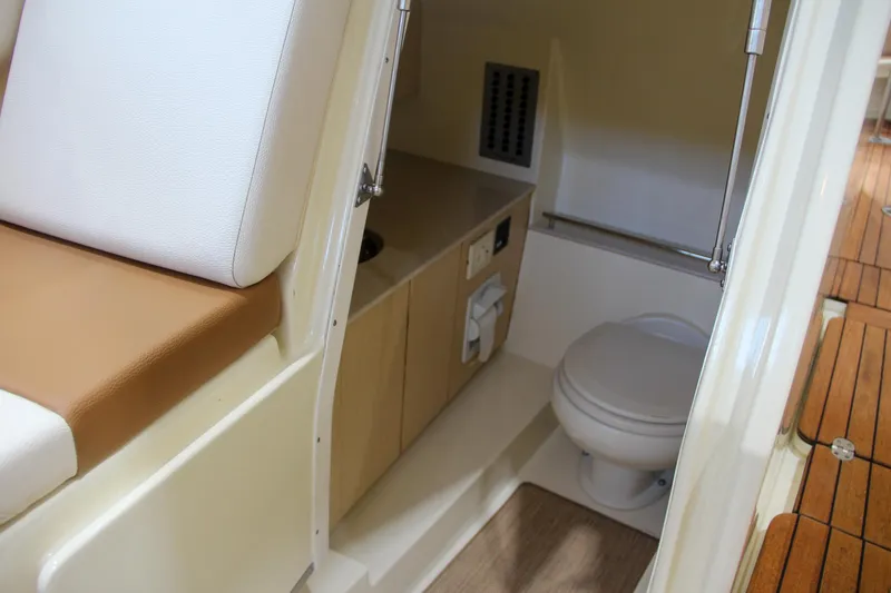 Slide: The Image of 2019 Chris-Craft Calypso 30 boat interior with toilet and seating area. - 32