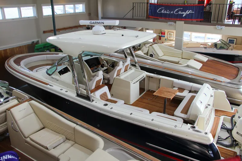 Slide: The Image of 2019 Chris-Craft Calypso 30 boat in showroom, featuring sleek design and luxury seating. - 39