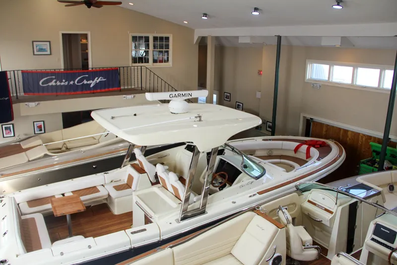Slide: The Image of 2019 Chris-Craft Calypso 30 boat displayed indoors with elegant seating and Garmin equipment. - 42