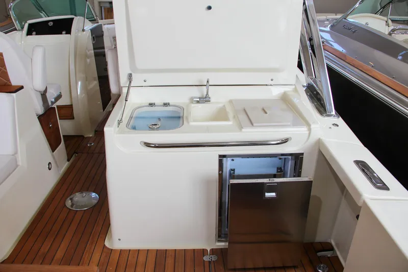 Slide: The Image of 2019 Chris-Craft Calypso 30 boat interior with kitchenette and wooden flooring. - 5