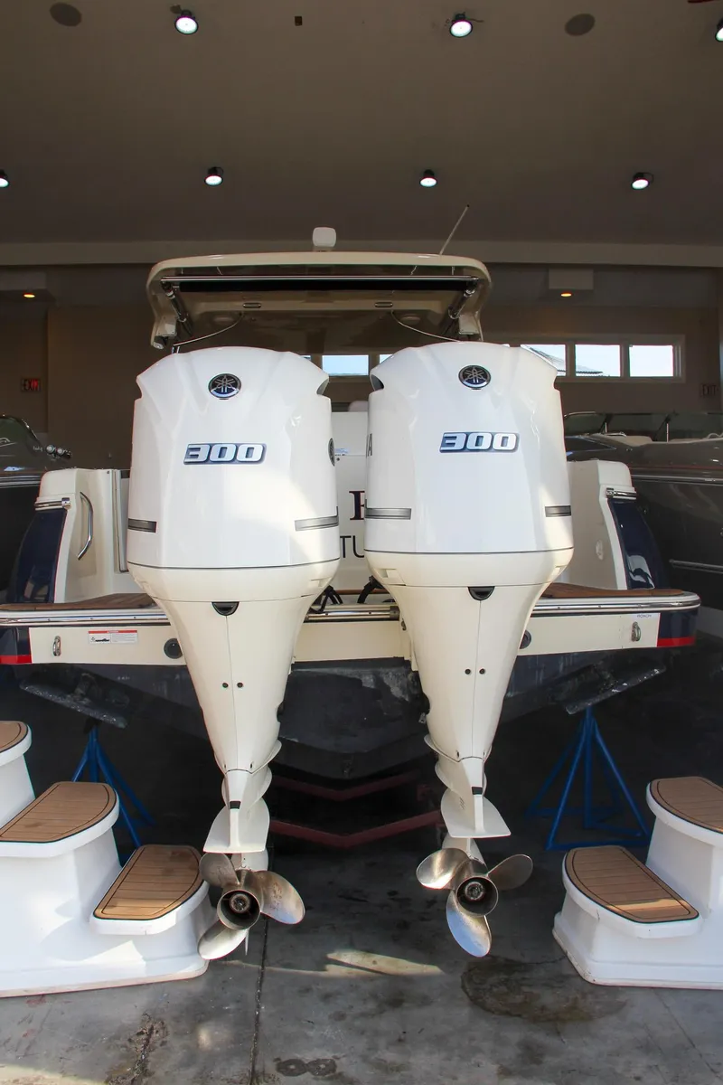 Slide: The Image of 2019 Chris-Craft Calypso 30 with twin 300 horsepower outboard engines in a showroom. - 7