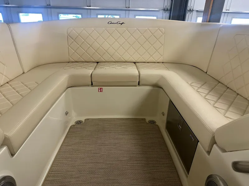 Slide: The Image of 2025 Chris-Craft Launch 27 interior with beige quilted seating and carpeted flooring. - 19