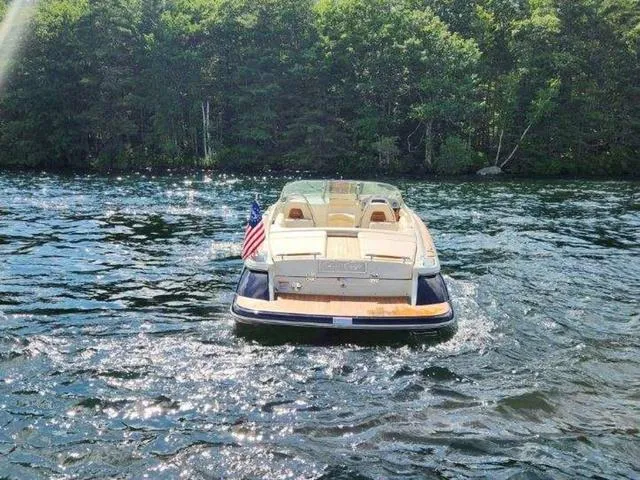 Slide: The Image of 2025 Chris-Craft Launch 27 boat cruising on a scenic lake with lush forest backdrop. - 4
