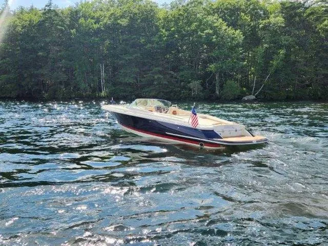 Slide: The Image of 2025 Chris-Craft Launch 27 boat cruising on a scenic lake with forested shoreline. - 5