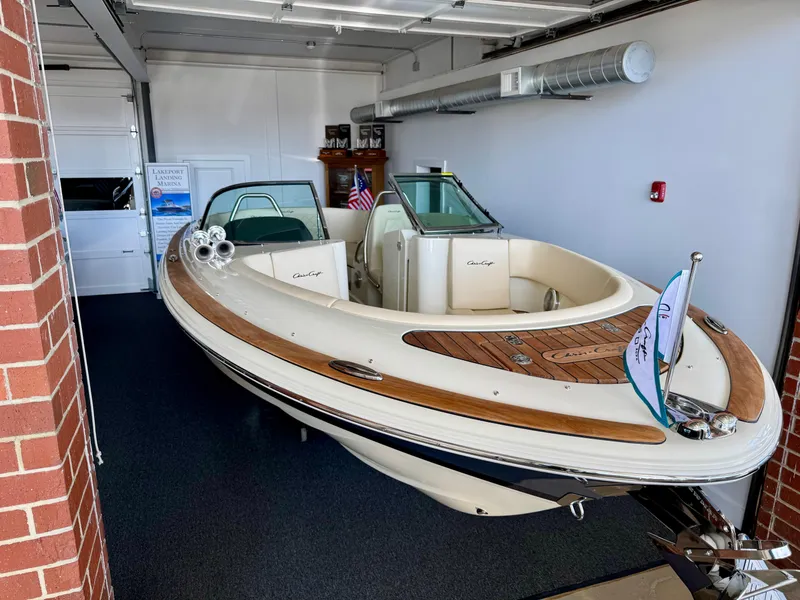 Slide: The Image of 2025 Chris-Craft Launch 27 boat displayed indoors, featuring elegant design and wood accents. - 2