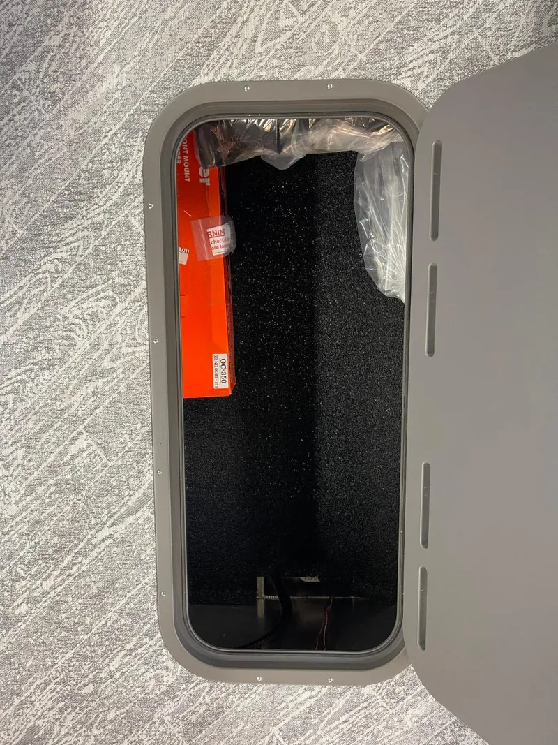 Slide: The Image of 2025 JC Spirit 247TT Sport storage compartment with carpeted interior and visible orange box. - 10