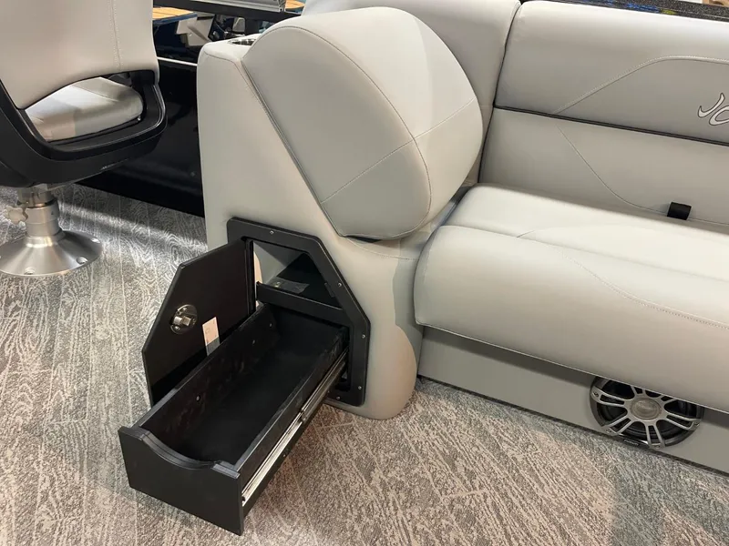 Slide: The Image of 2025 JC Spirit 247TT Sport interior with open storage drawer and gray seating. - 20