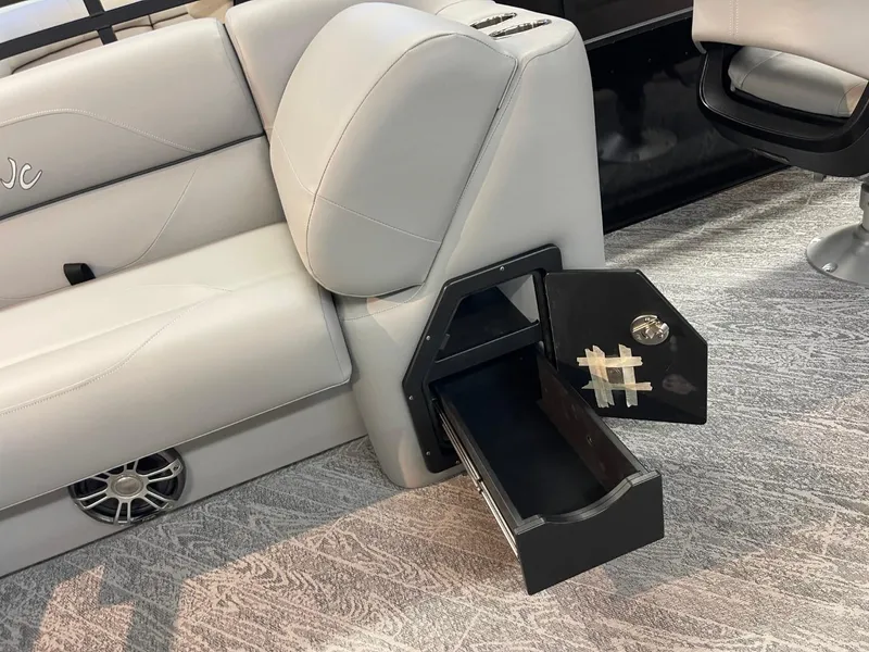 Slide: The Image of 2025 JC Spirit 247TT Sport boat interior with open storage compartment and luxurious seating. - 21