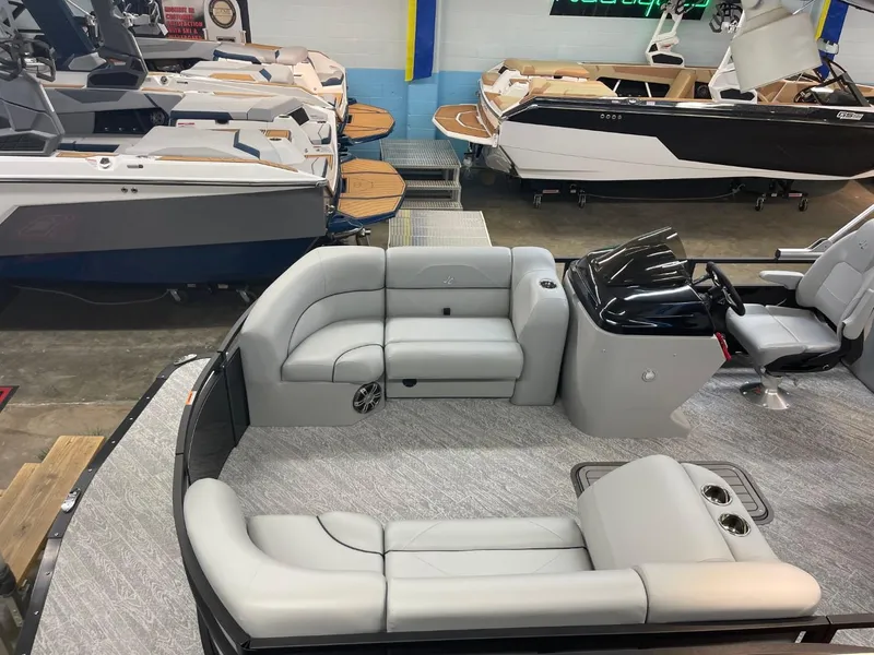 Slide: The Image of 2025 JC Spirit 247TT Sport pontoon boat interior with sleek seating in showroom. - 36