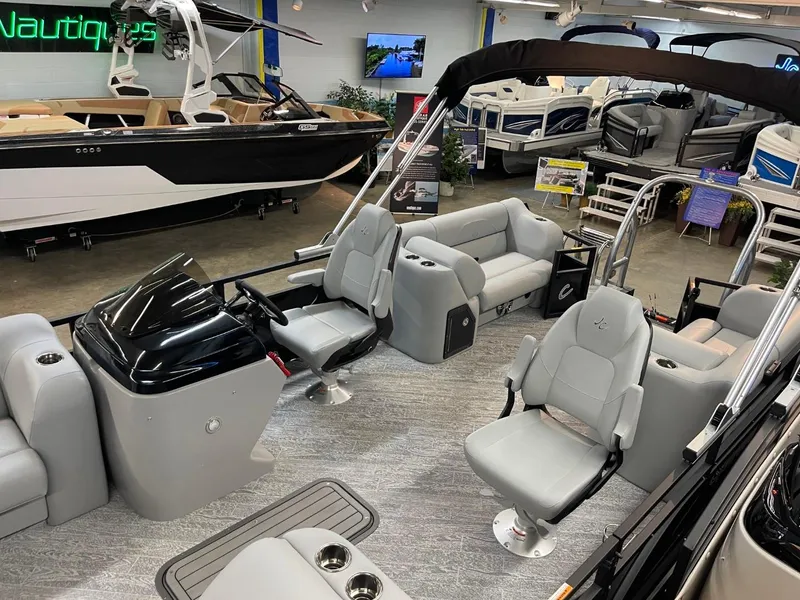 Slide: The Image of 2025 JC Spirit 247TT Sport pontoon boat interior in showroom, featuring modern seating and helm. - 37