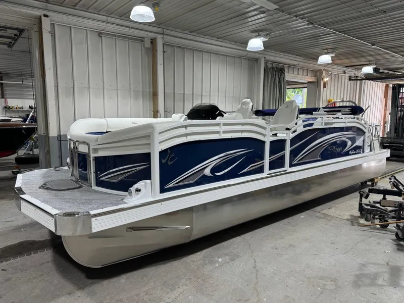 Slide: The Image of 2025 JC Swingback 25 TT pontoon boat in a garage setting. - 1