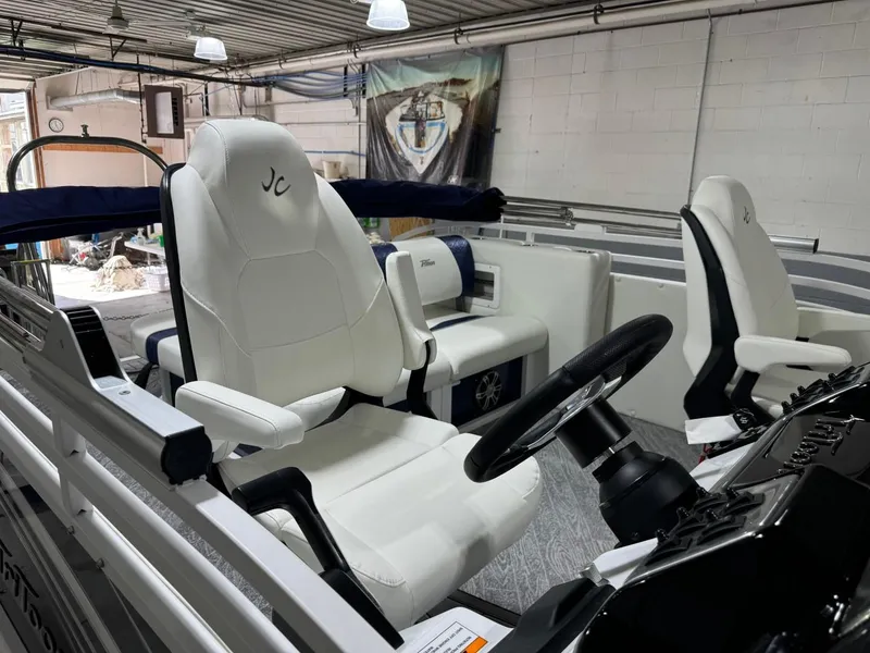 Slide: The Image of 2025 JC Swingback 25 TT boat interior with white seating and steering wheel. - 10