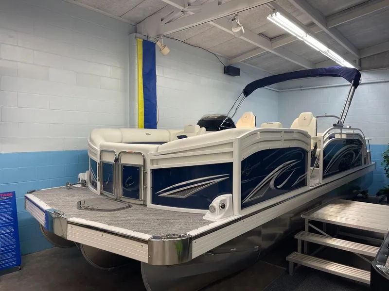 Slide: The Image of 2025 JC Swingback 25 TT pontoon boat in showroom, featuring sleek design and comfortable seating. - 13