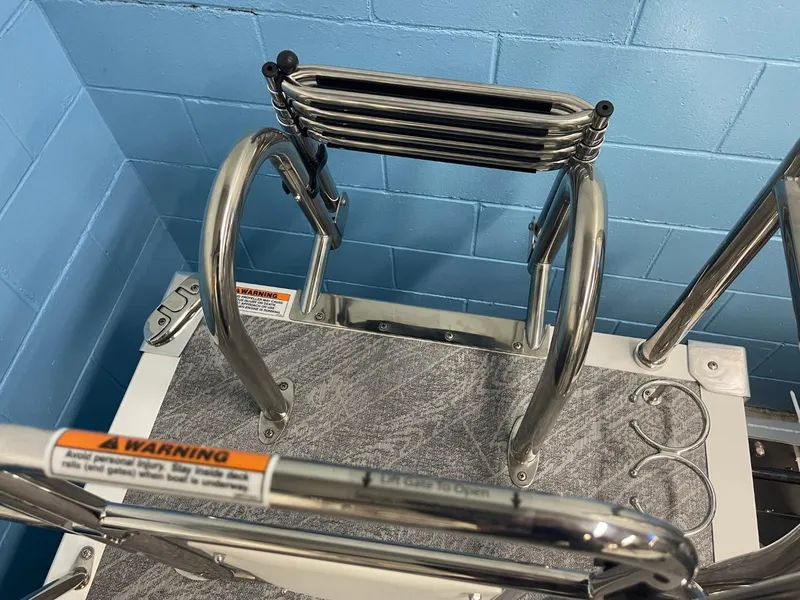 Slide: The Image of Stainless steel ladder on JC Swingback 25 TT, 2025 model, with warning labels. - 32