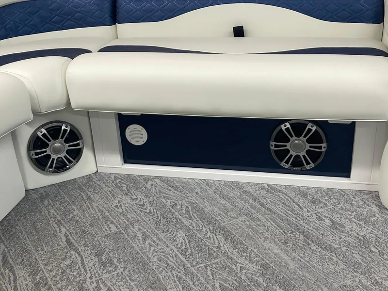 Slide: The Image of 2025 JC Swingback 25 TT boat interior with blue and white seating and built-in speakers. - 46