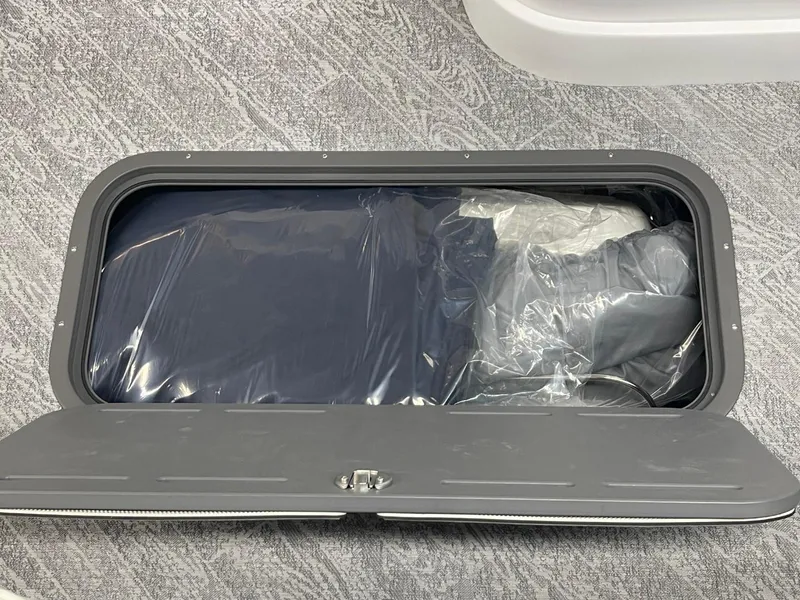 Slide: The Image of Storage compartment in a 2025 JC Swingback 25 TT boat, with items inside. - 48