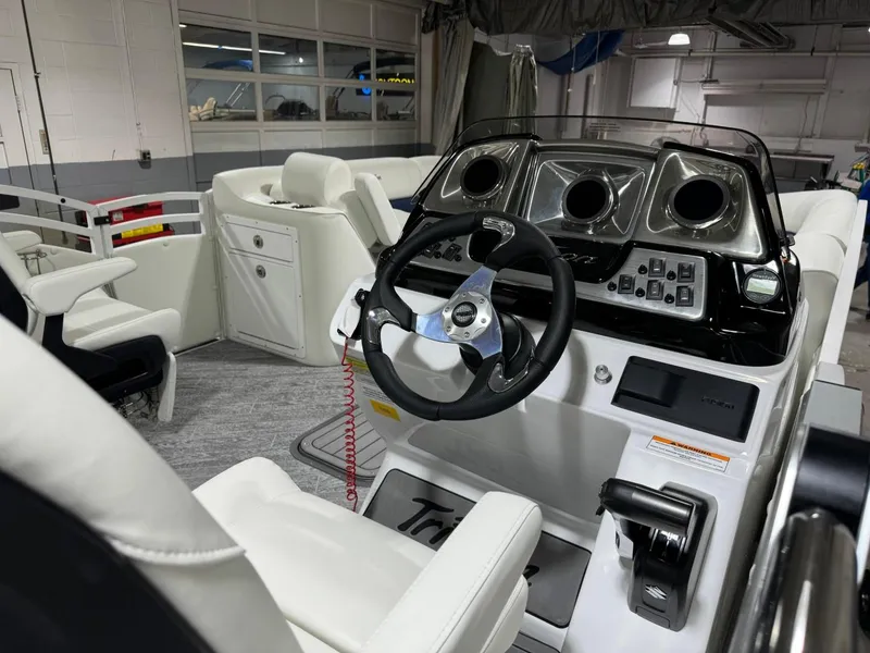 Slide: The Image of 2025 JC Swingback 25 TT boat interior with modern steering console and white seating. - 9
