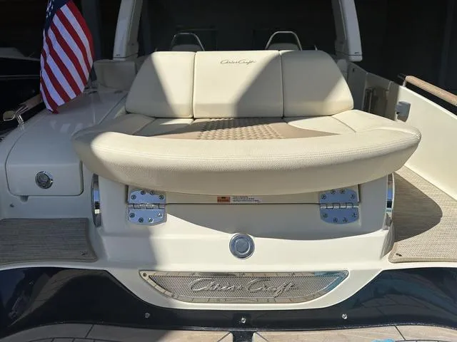 Slide: The Image of 2025 Chris-Craft Launch 28 GT boat with beige seating and American flag. - 3
