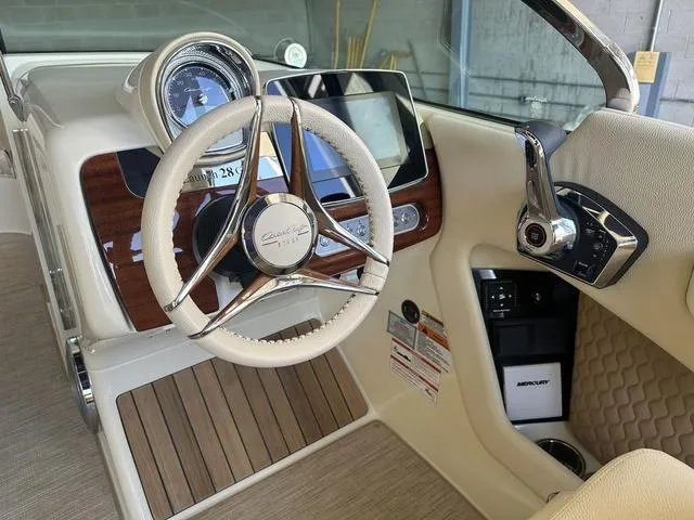 Slide: The Image of 2025 Chris-Craft Launch 28 GT dashboard with steering wheel and modern controls. - 8