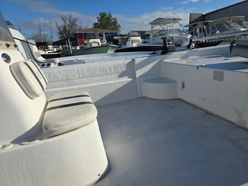 Slide: The Image of 2011 Carolina Skiff 218 DLV boat interior with seating, docked under clear sky. - 11