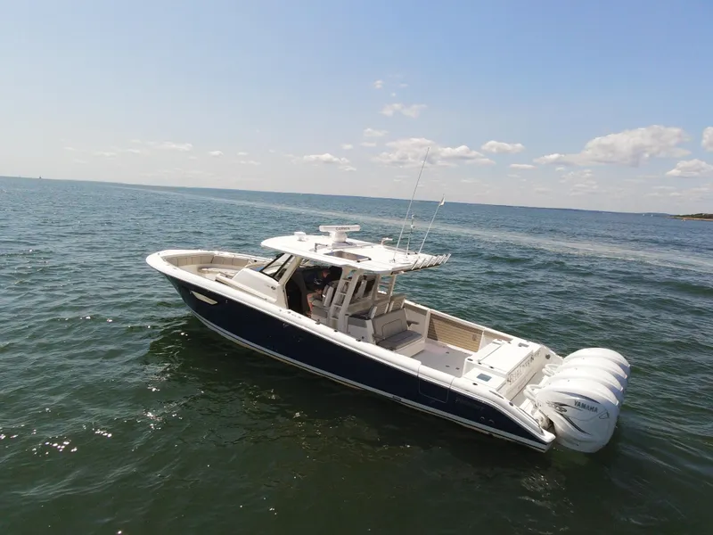 The Image of 2021 Pursuit S 428 Sport boat cruising on open water under a clear sky. - 0