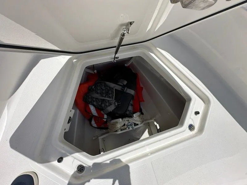 Slide: The Image of Storage compartment on 2021 Pursuit S 428 Sport boat with life jackets and gear. - 13