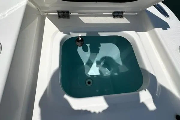 Slide: The Image of Livewell compartment on 2021 Pursuit S 428 Sport boat, open lid, sunlight casting shadows. - 18