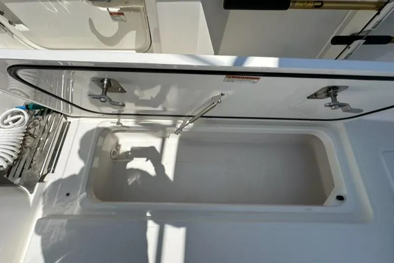 Slide: The Image of Open storage compartment on 2021 Pursuit S 428 Sport boat. - 19