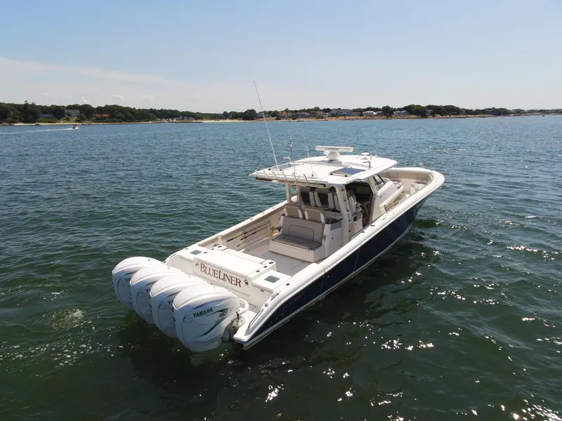 Slide: The Image of 2021 Pursuit S 428 Sport boat on open water, featuring four powerful engines. - 2