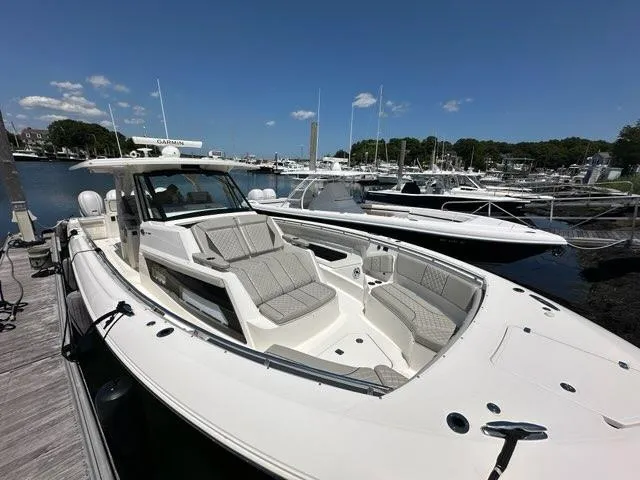 Slide: The Image of 2021 Pursuit S 428 Sport boat docked at marina under clear blue sky. - 27