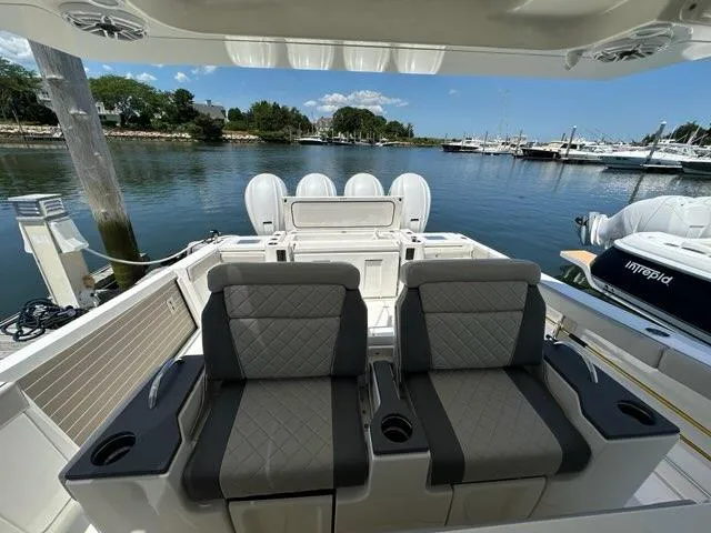 Slide: The Image of 2021 Pursuit S 428 Sport boat interior with dual seats, docked in a marina. - 30