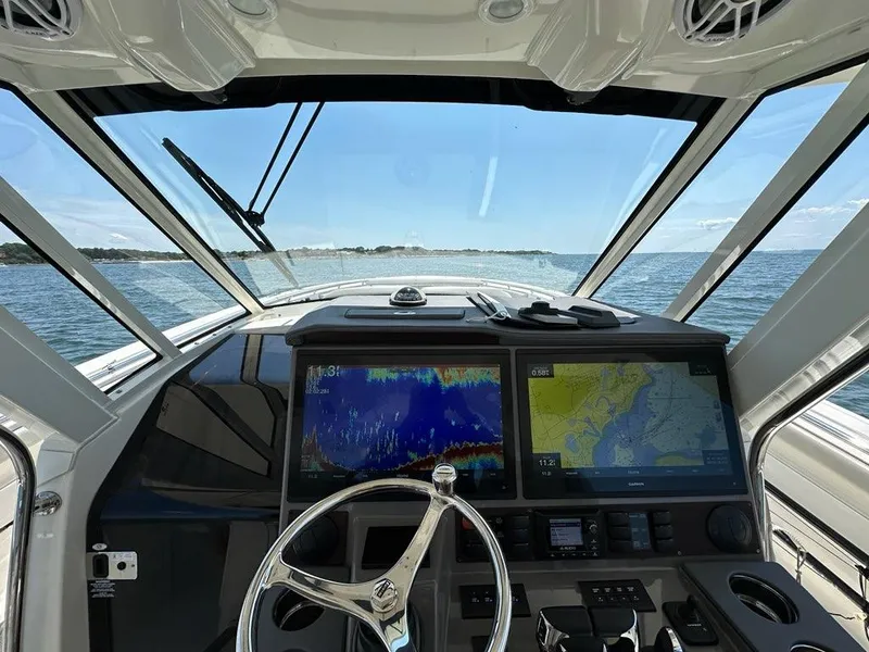 Slide: The Image of 2021 Pursuit S 428 Sport boat dashboard with navigation screens on open water. - 32