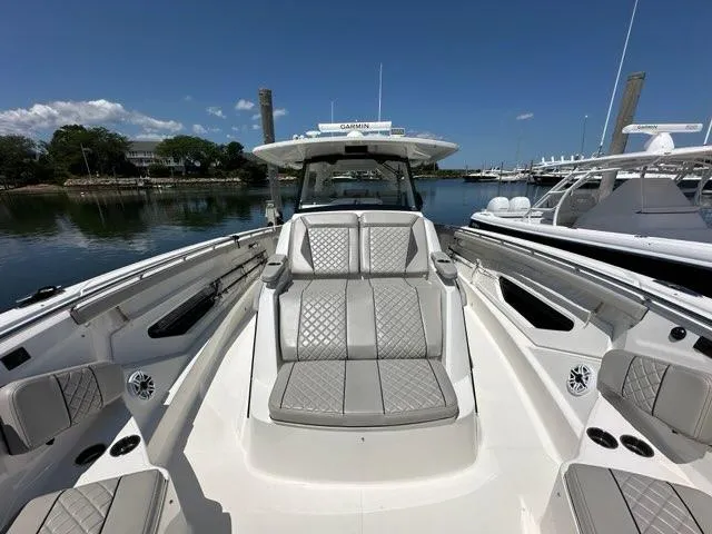 Slide: The Image of 2021 Pursuit S 428 Sport boat with luxurious seating and sleek design in a marina. - 37