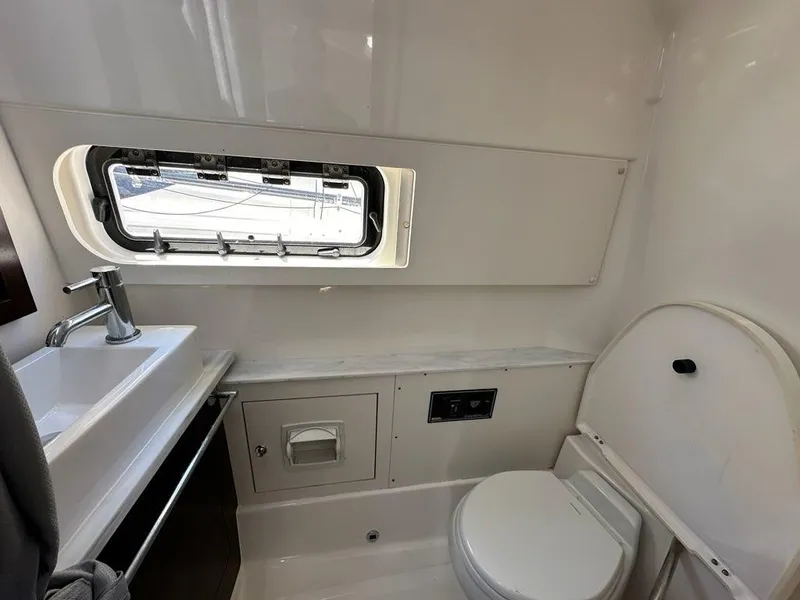 Slide: The Image of 2021 Pursuit S 428 Sport boat bathroom with sink, toilet, and window. - 42