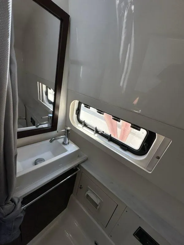 Slide: The Image of 2021 Pursuit S 428 Sport boat bathroom with sink and window. - 43