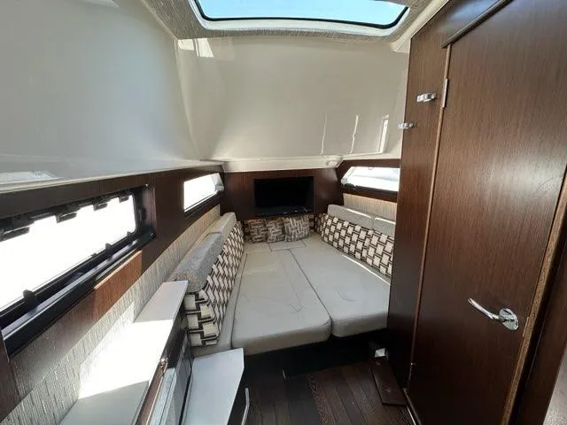 Slide: The Image of 2021 Pursuit S 428 Sport cabin interior with modern seating and natural light. - 47