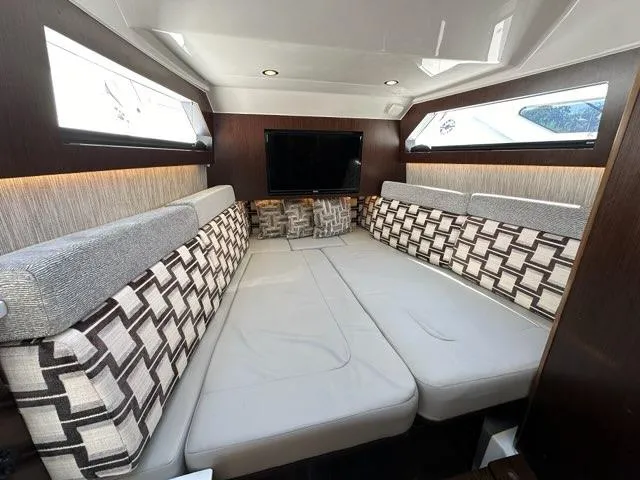 Slide: The Image of Luxurious interior cabin of 2021 Pursuit S 428 Sport boat with modern seating and TV. - 48