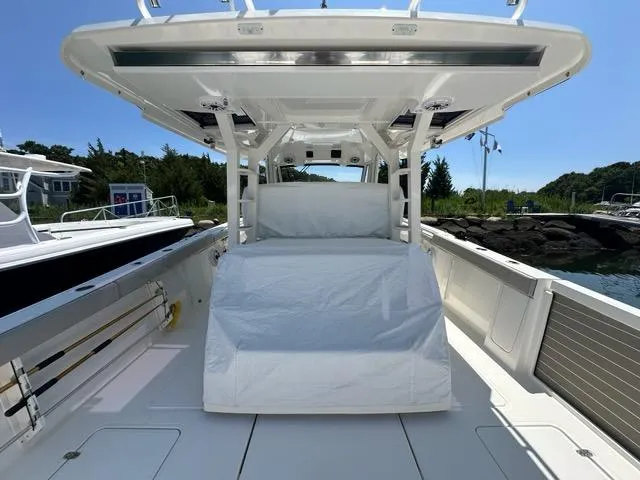 Slide: The Image of 2021 Pursuit S 428 Sport boat interior, featuring spacious deck and covered seating. - 5