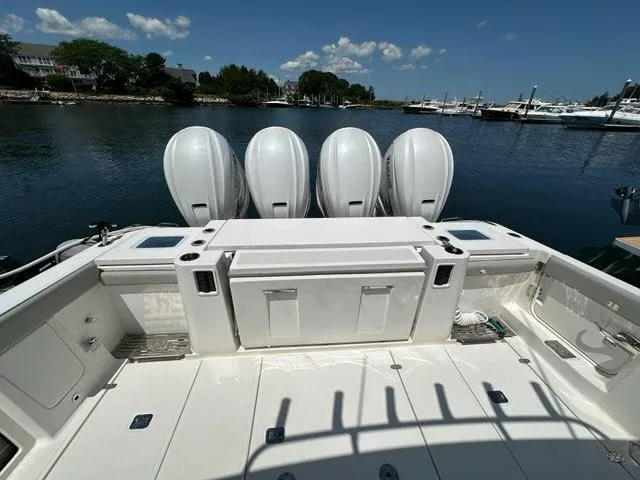 Slide: The Image of 2021 Pursuit S 428 Sport boat with four powerful outboard engines docked by the water. - 6