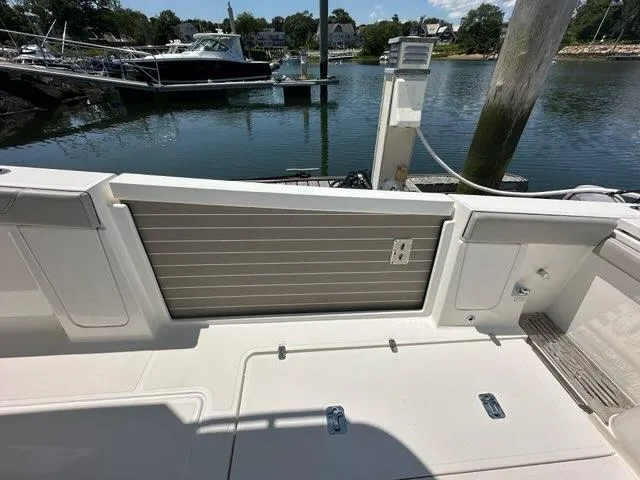 Slide: The Image of 2021 Pursuit S 428 Sport boat docked at marina, showcasing deck and water view. - 8