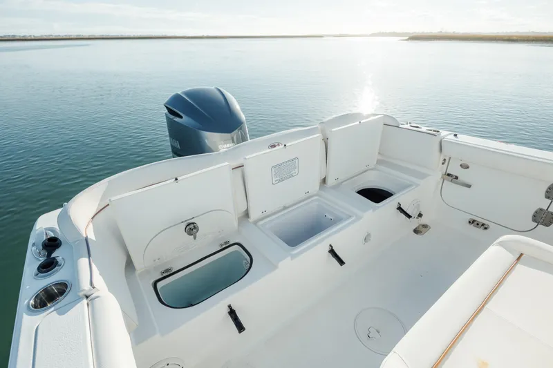 Slide: The Image of 2021 Sea Hunt Ultra 255 SE boat interior with engine, on calm water. - 11