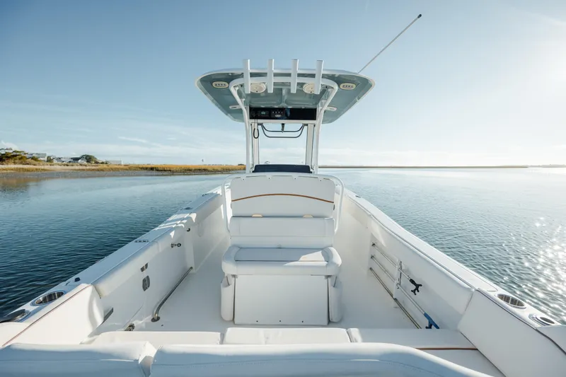 Slide: The Image of 2021 Sea Hunt Ultra 255 SE boat on calm water, clear sky. - 13
