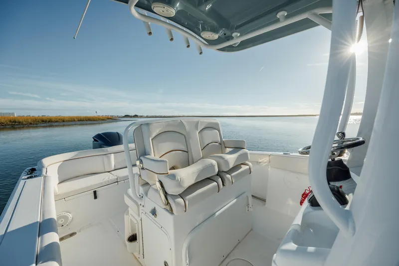 Slide: The Image of 2021 Sea Hunt Ultra 255 SE boat interior with seating, on calm water. - 15
