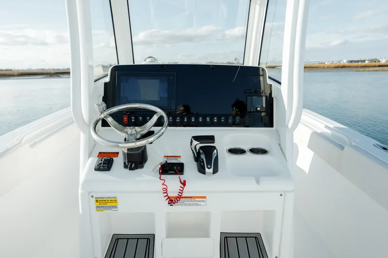 Slide: The Image of 2021 Sea Hunt Ultra 255 SE boat dashboard with steering wheel and controls. - 17
